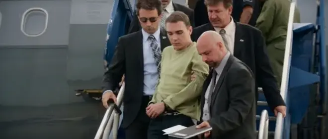 Luka Magnotta gets off a plane escorted by law enforcement