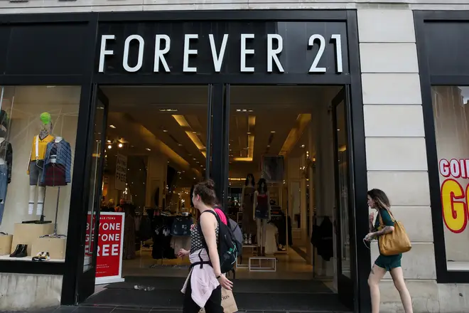Shoppers walk past a branch of Forever 21 store in central...